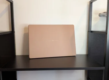 Portátil ASUS Zenbook bege pousado numa prateleira preta.