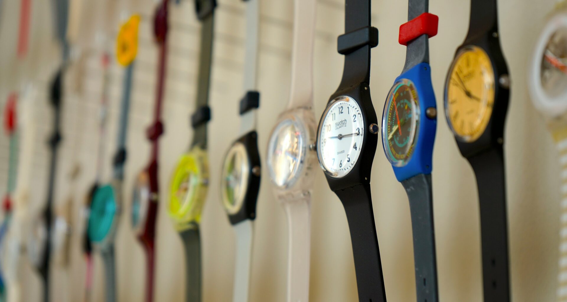Coleção de relógios coloridos pendurados na parede.