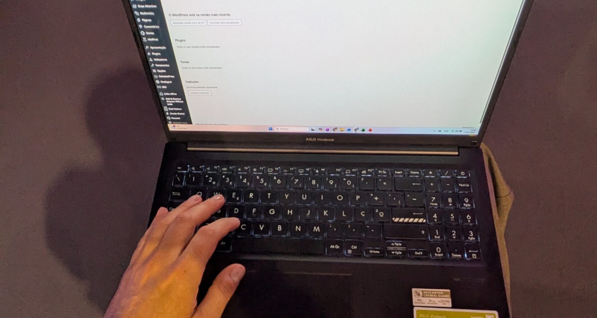Pessoa utilizando laptop ASUS com WordPress aberto