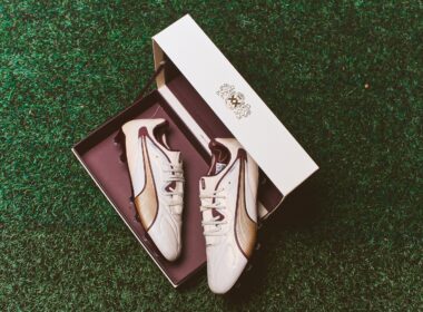 Botas de futebol brancas dentro de caixa elegante.