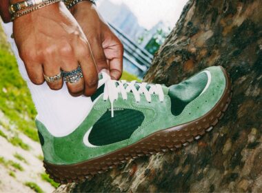 Pessoa a ajustar sapatos desportivos verdes em árvore.