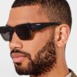 Homem com óculos de sol Prada pretos.