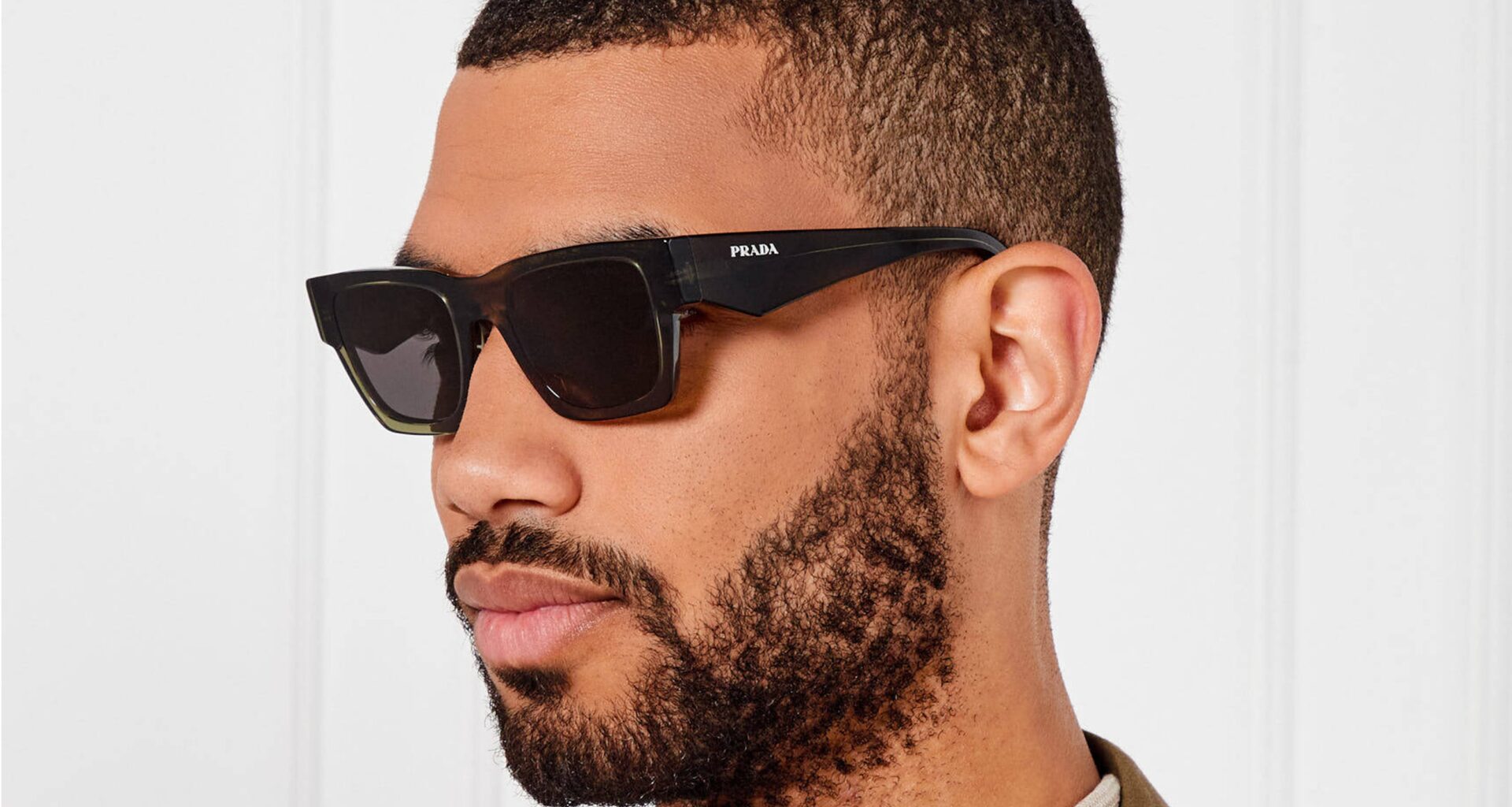 Homem com óculos de sol Prada pretos.