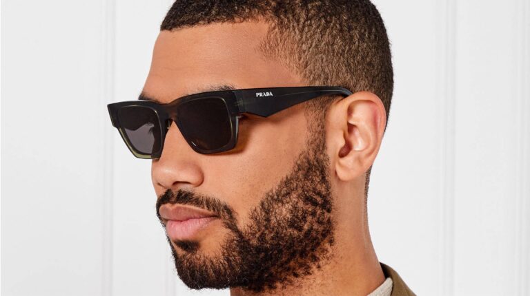 Homem com óculos de sol Prada pretos.