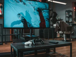 Consolas e TV a exibir snowboard na barbearia.