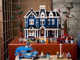 Casa de LEGO azul com personagens e veículos.