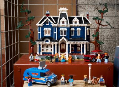 Casa de LEGO azul com personagens e veículos.