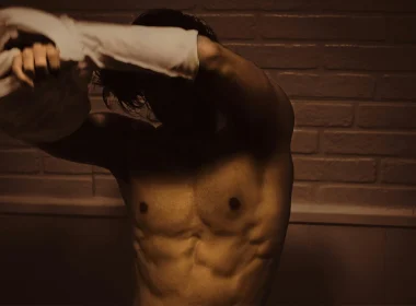 Homem sem camisa a secar-se com toalha.