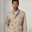 Homem com casaco bege estilo safari.