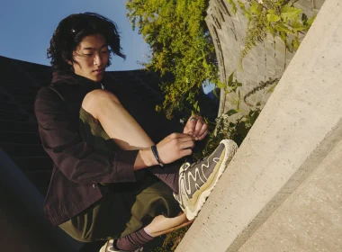 Jovem a atar atacador de sapatilha Merrell junto a concreto.