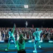 Multidão a fazer exercício em aula de fitness com instrutores.