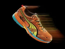 Sapatilha de corrida Puma laranja com efeito de movimento.