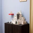 Modelo LEGO de Minas Tirith exposto sobre um armário escuro.