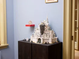 Modelo LEGO de Minas Tirith exposto sobre um armário escuro.