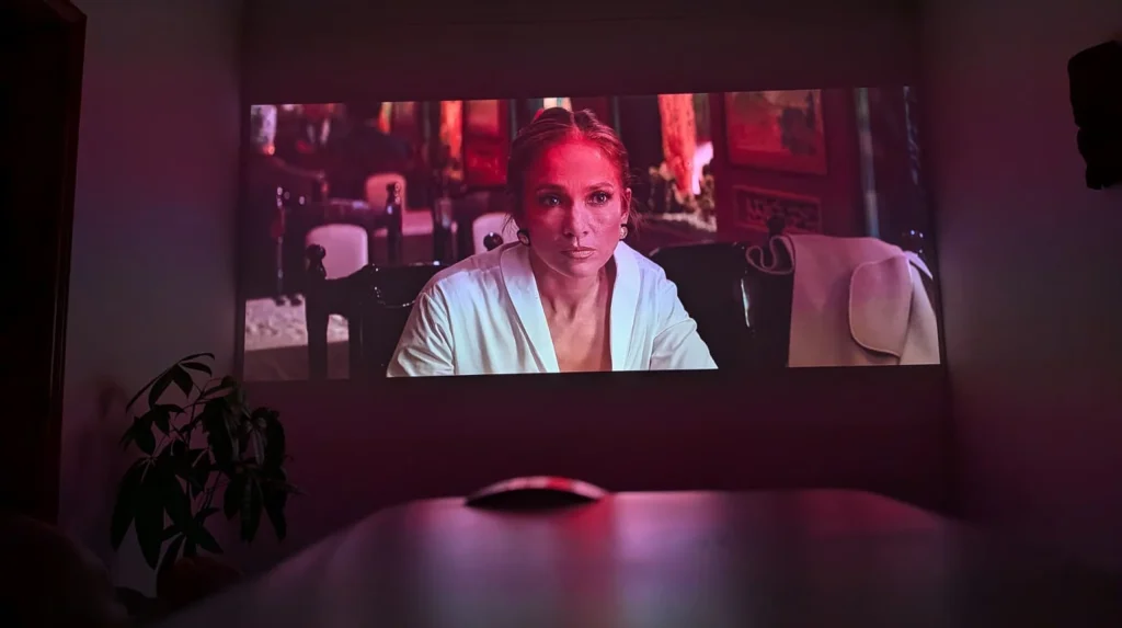 Projeção de Jennifer Lopez num ecrã em sala escura.