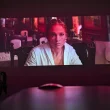 Projeção de Jennifer Lopez num ecrã em sala escura.