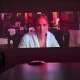 Projeção de Jennifer Lopez num ecrã em sala escura.