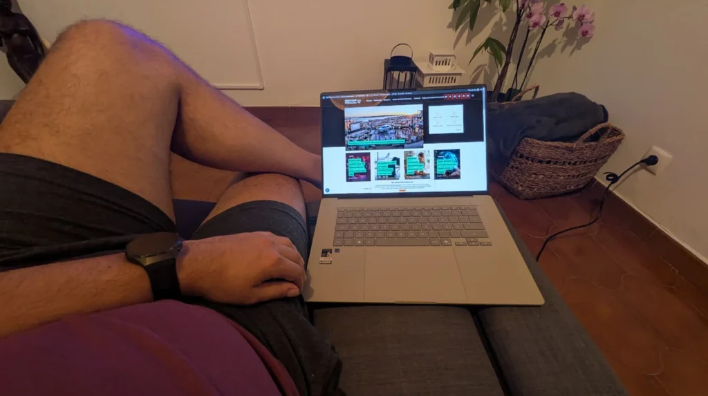 Homem a utilizar um portátil sentado confortavelmente no sofá.