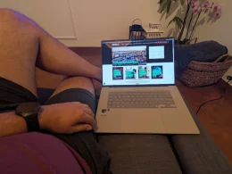Homem a utilizar um portátil sentado confortavelmente no sofá.