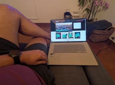 Homem a utilizar um portátil sentado confortavelmente no sofá.