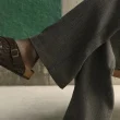 Pessoa a usar sandálias Birkenstock castanhas e calças cinzentas.