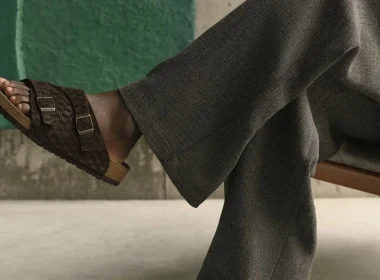 Pessoa a usar sandálias Birkenstock castanhas e calças cinzentas.