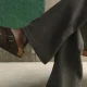 Pessoa a usar sandálias Birkenstock castanhas e calças cinzentas.