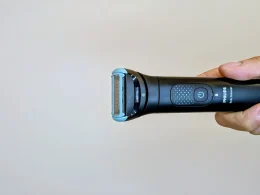 Máquina de depilação Philips Body Groomer segurada por uma mão.