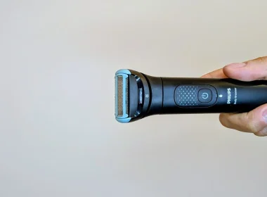 Máquina de depilação Philips Body Groomer segurada por uma mão.