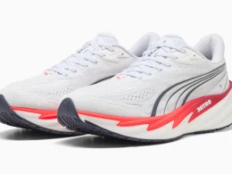 Sapatilhas de corrida Puma brancas com detalhes em vermelho.