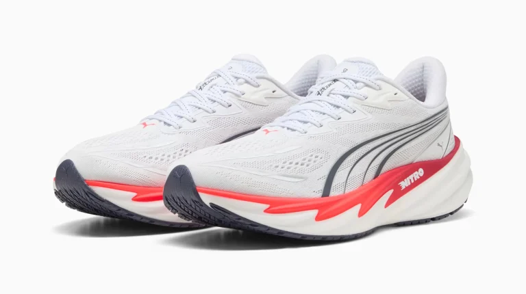 Sapatilhas de corrida Puma brancas com detalhes em vermelho.