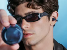 Homem com óculos de sol e auriculares azuis tecnológicos.