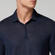 Homem a usar um polo azul marinho de manga curta.