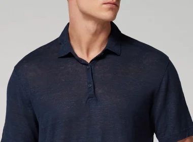 Homem a usar um polo azul marinho de manga curta.