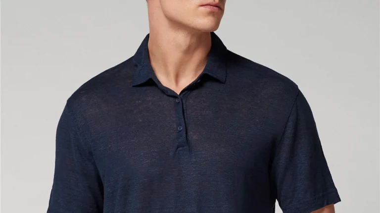 Homem a usar um polo azul marinho de manga curta.