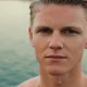 Retrato de um jovem com o rosto e cabelo molhados.