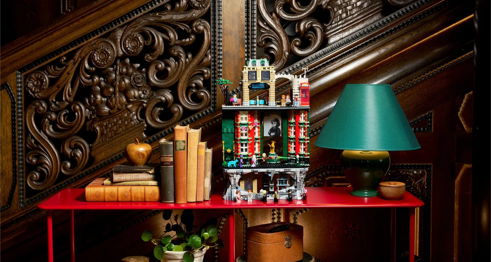 LEGO Ministério da Magia em prateleira vermelha com livros antigos.