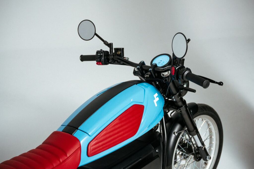 Motocicleta azul e vermelha vista de lado.