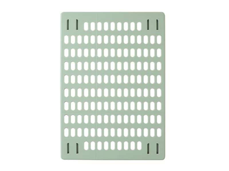 Grelha plástica verde clara com aberturas ovais.