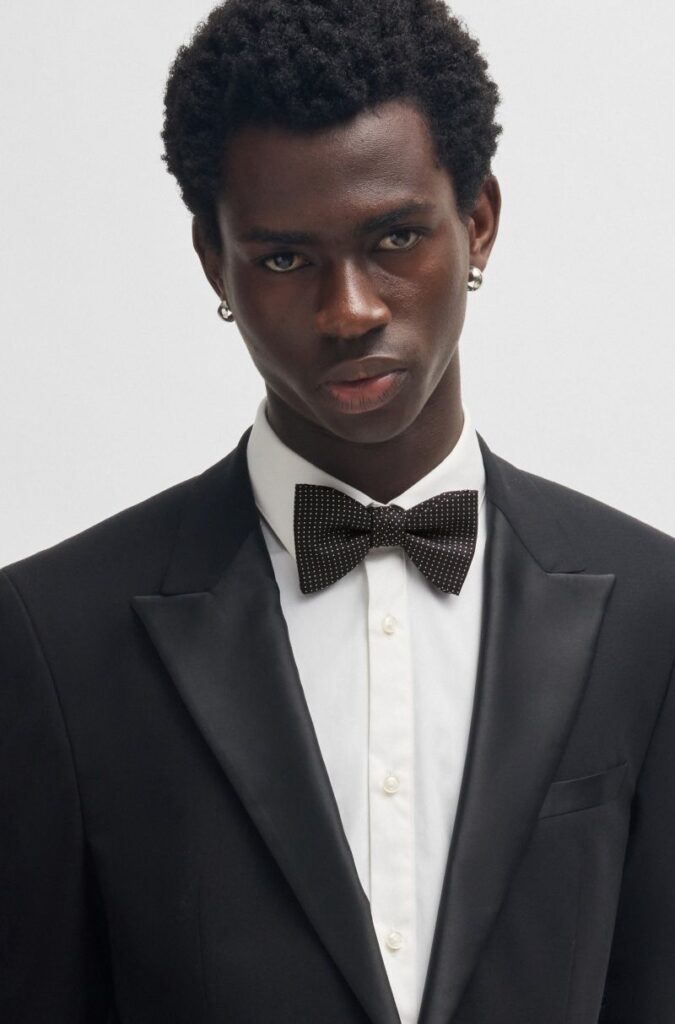 Homem em fato preto e laço.
