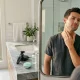 Homem a observar-se ao espelho após rotina de cuidados.