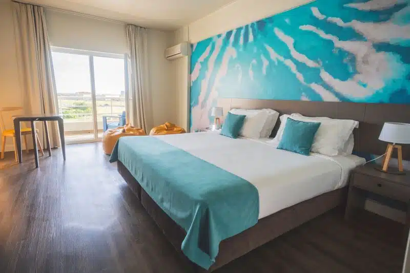 Quarto moderno com cama de casal e varanda.