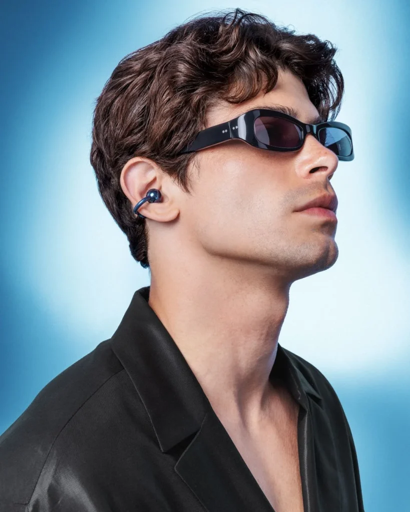 Homem com óculos de sol e auriculares de design inovador.