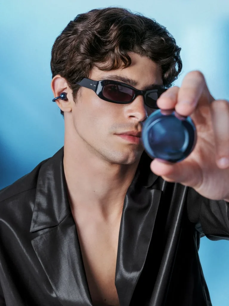 Homem com óculos de sol e auriculares azuis tipo clipe.