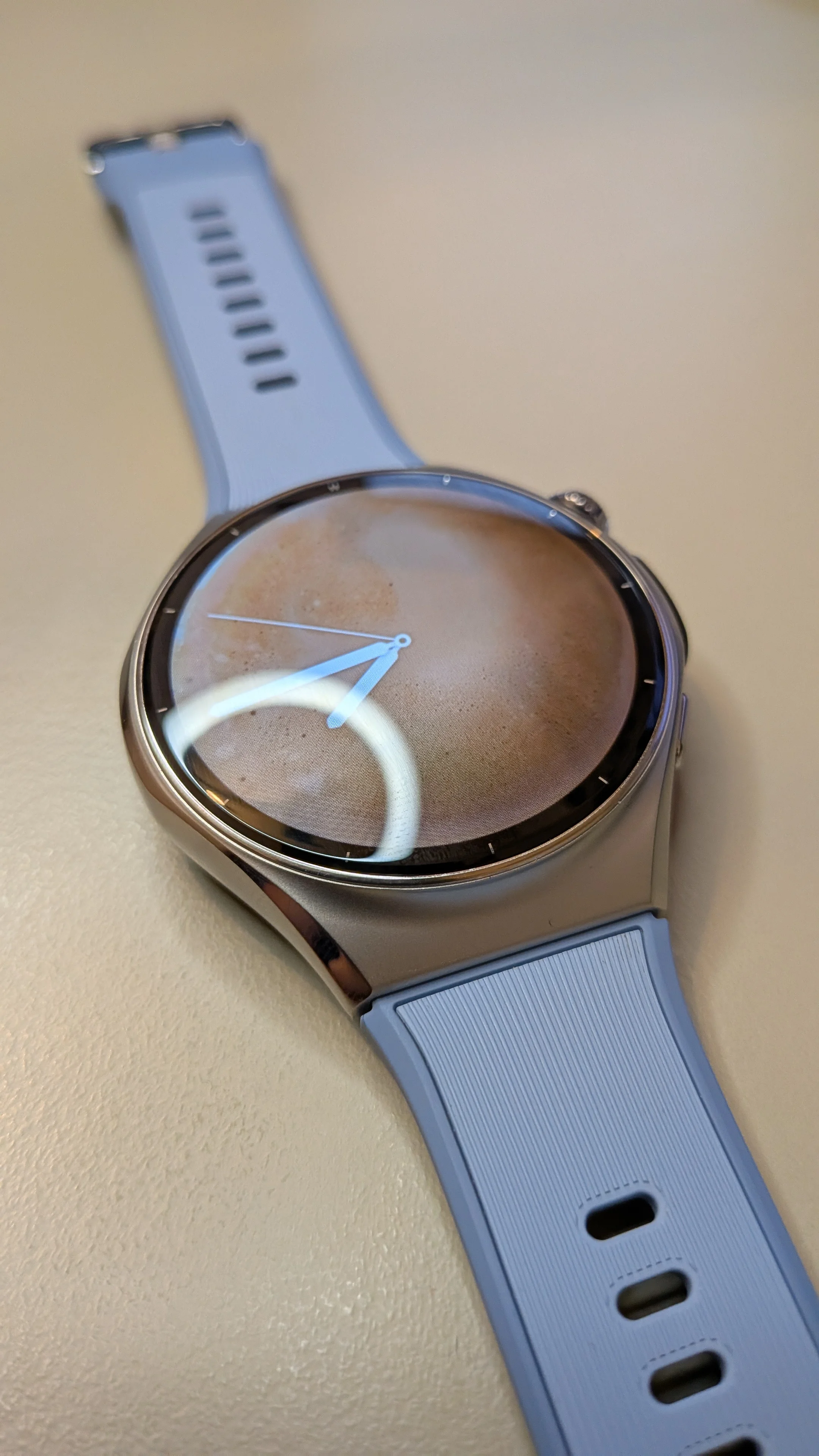 Smartwatch Huawei Watch 6 prateado com ecrã de bordas infinitas e bracelete azul clara sobre superfície plana