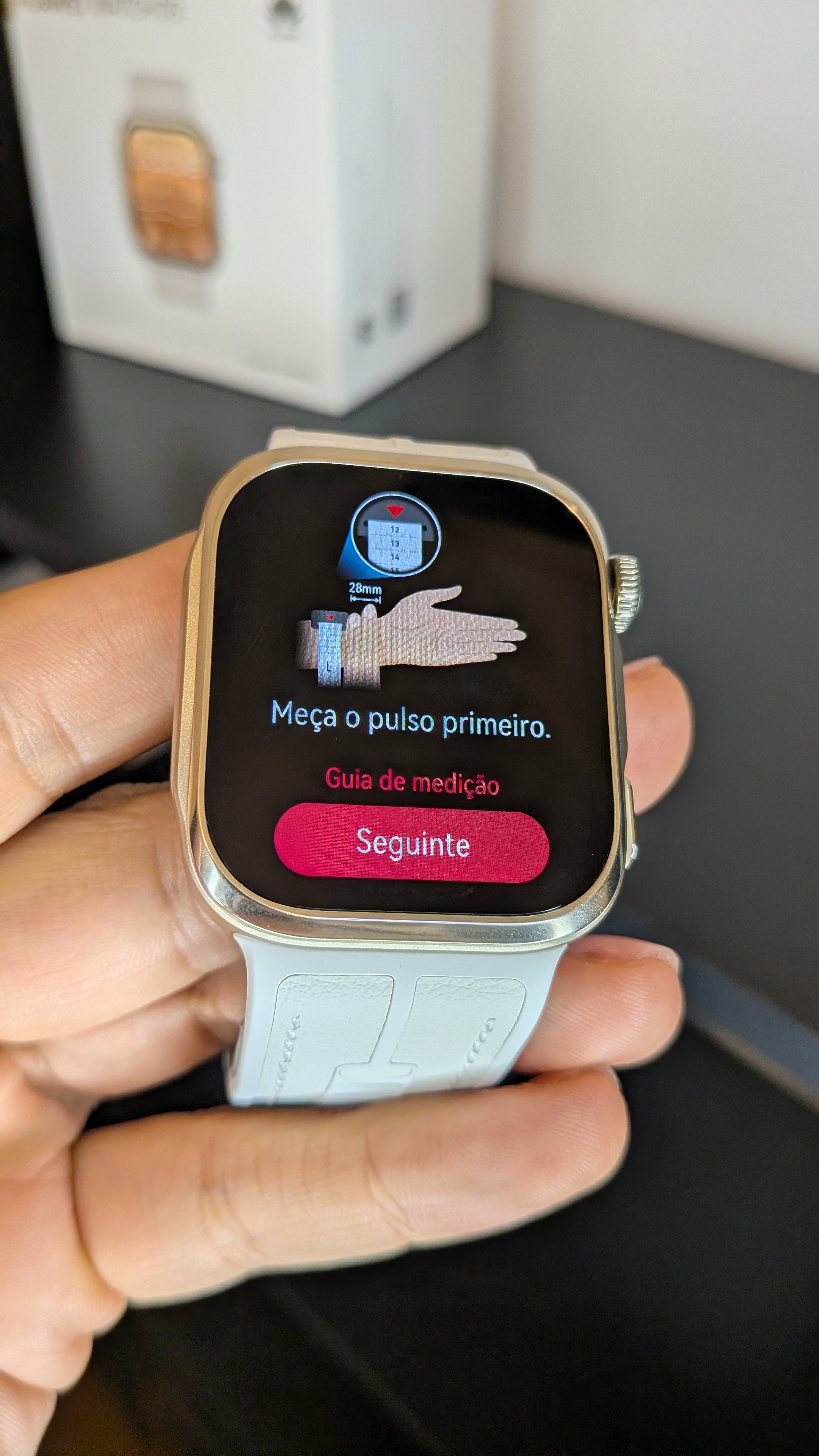Mão a segurar o smartwatch Huawei Watch D3 com o ecrã a exibir o guia de medição e a instrução para medir o pulso.