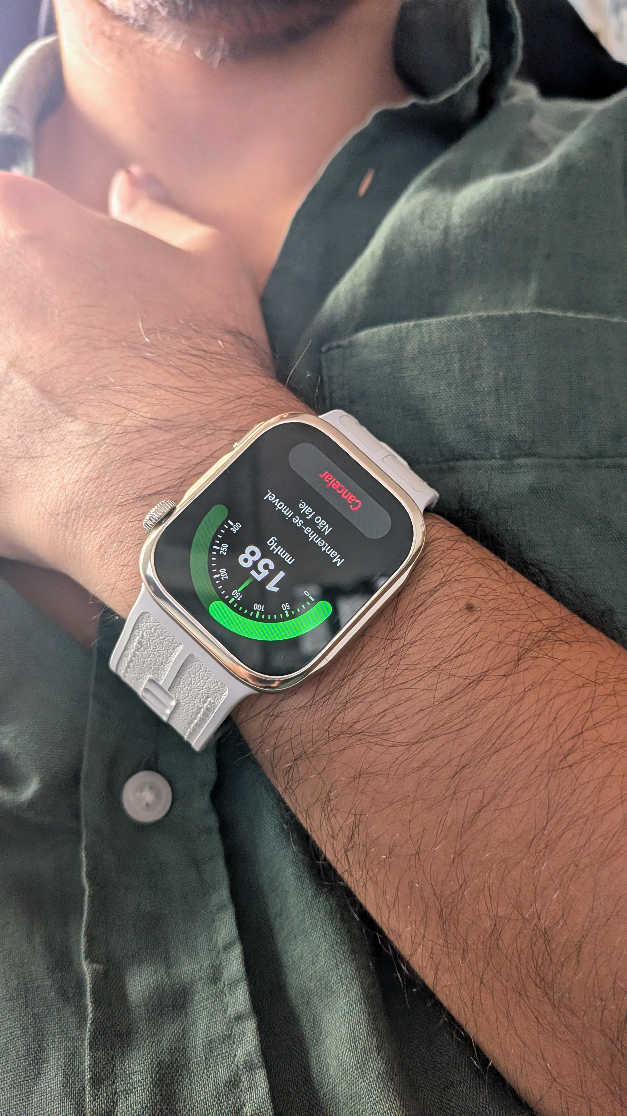 Pulso de um homem com o smartwatch Huawei Watch D3 a medir a tensão arterial, exibindo um gráfico verde e a mensagem mantenha-se imóvel no ecrã.