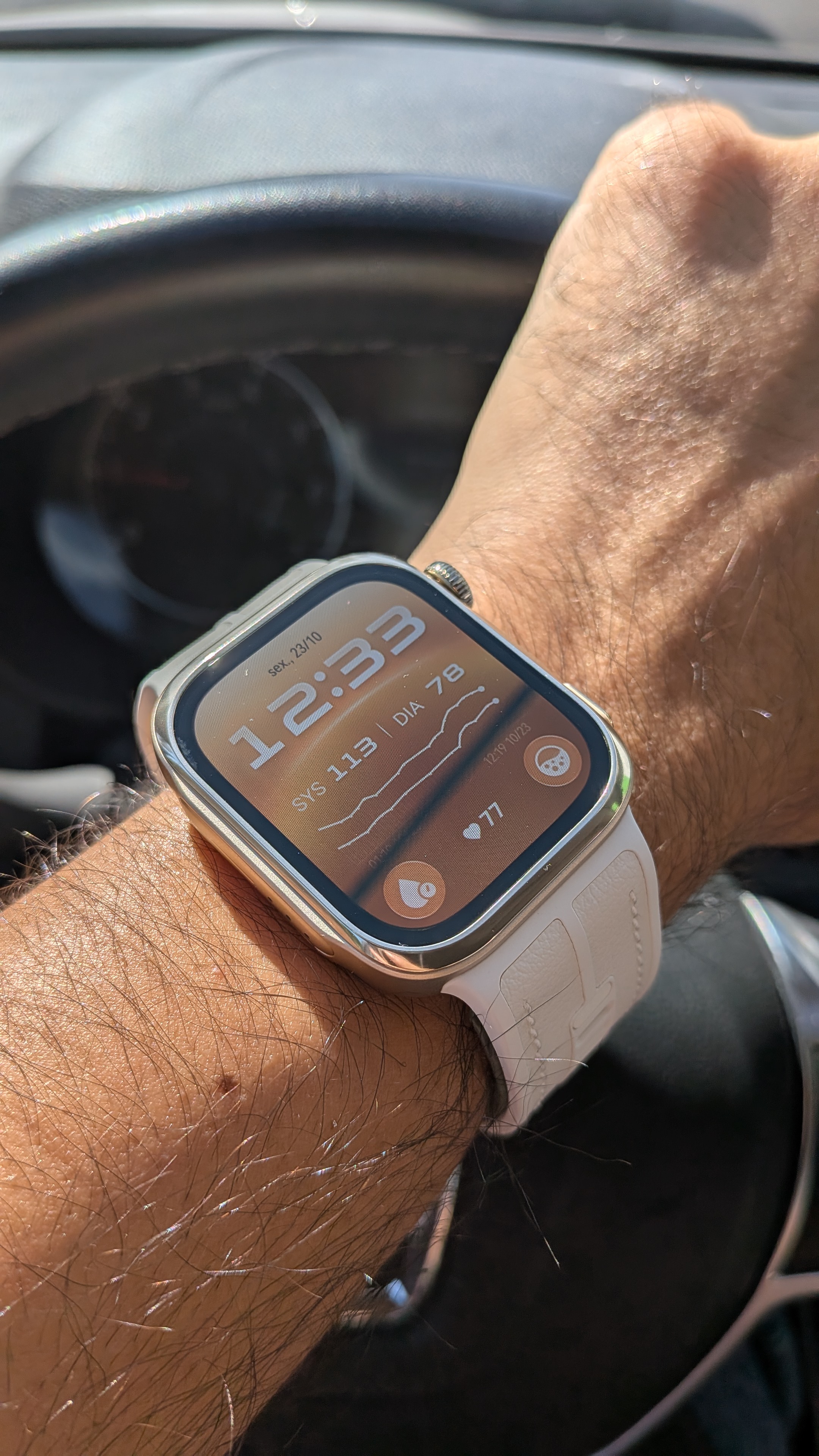 Pulso masculino a usar o smartwatch Huawei Watch D3 com bracelete branca, exibindo valores de tensão arterial e ritmo cardíaco no ecrã digital.