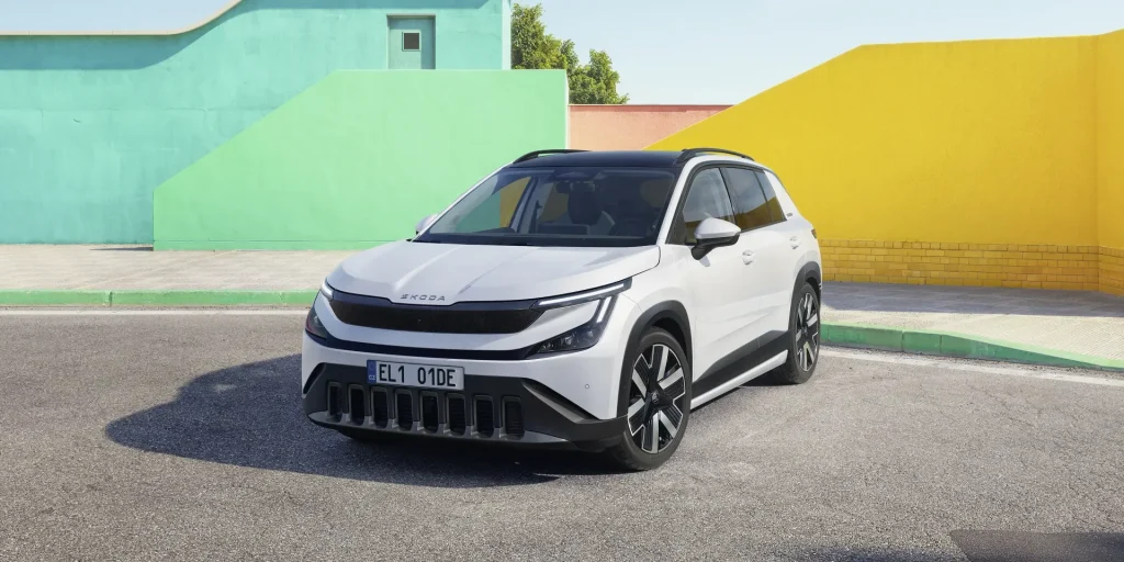 Škoda Elroq branco estacionado em frente a paredes coloridas.