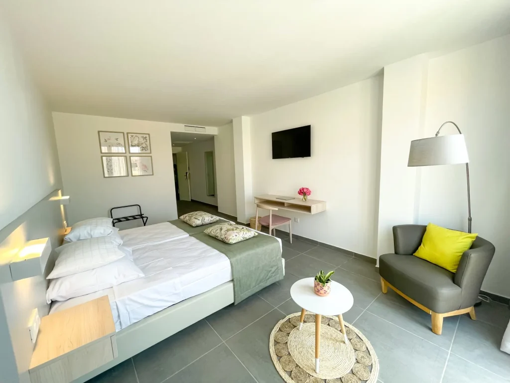 Quarto luminoso e moderno com cama branca e decoração minimalista.